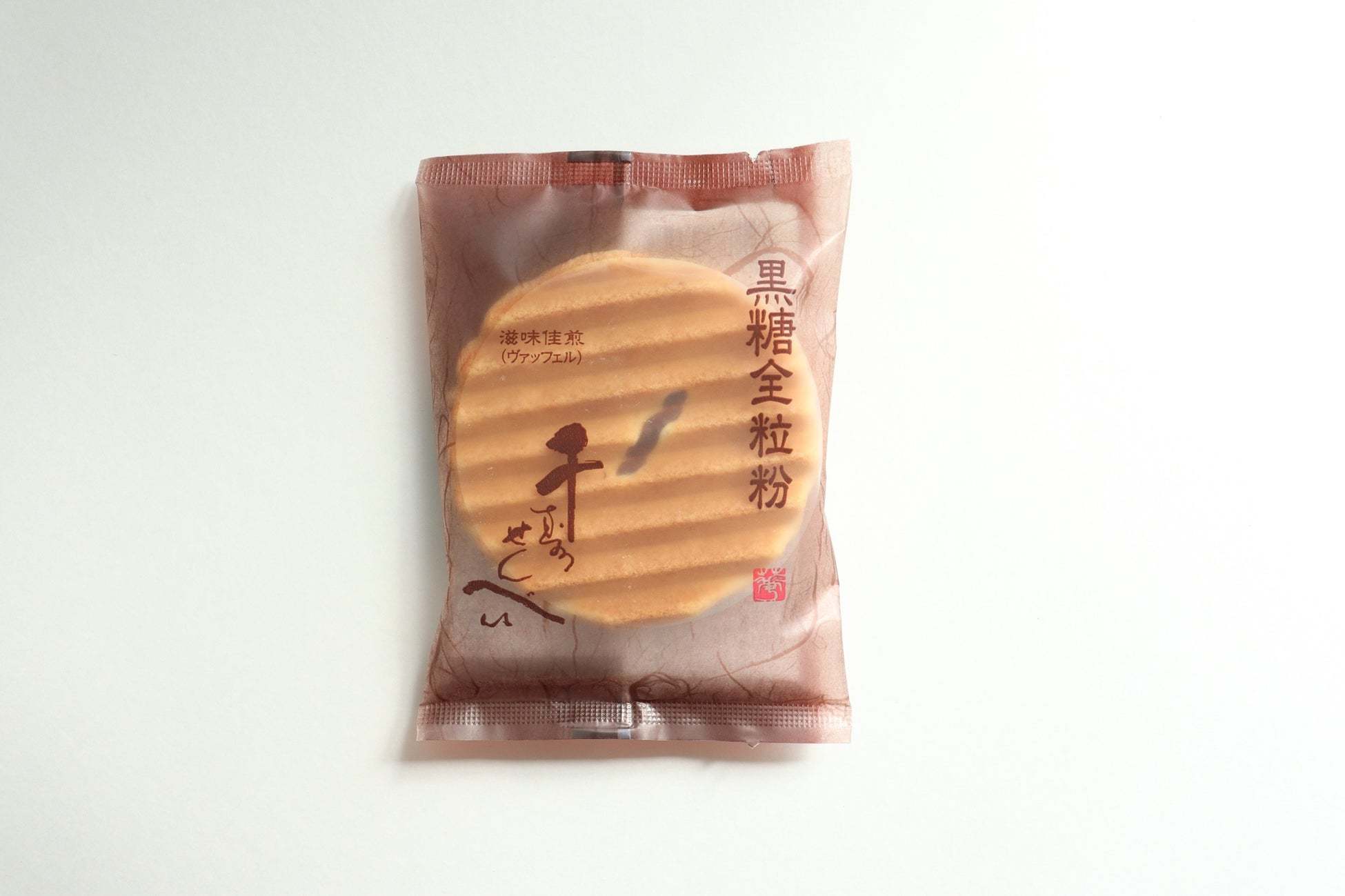 関西地区セブン-イレブンにて好評販売中の鼓月看板商品「千寿せんべい」につづいて、4月19日から第二弾となる「黒糖全粒粉千寿せんべい」を順次販売へ