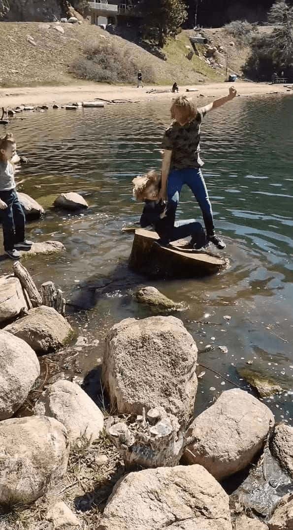 水辺に浮かぶ大きな丸太に乗る男の子。弟くんもそこに飛び乗ろうとしましたが、足を滑らせてしまい・・・