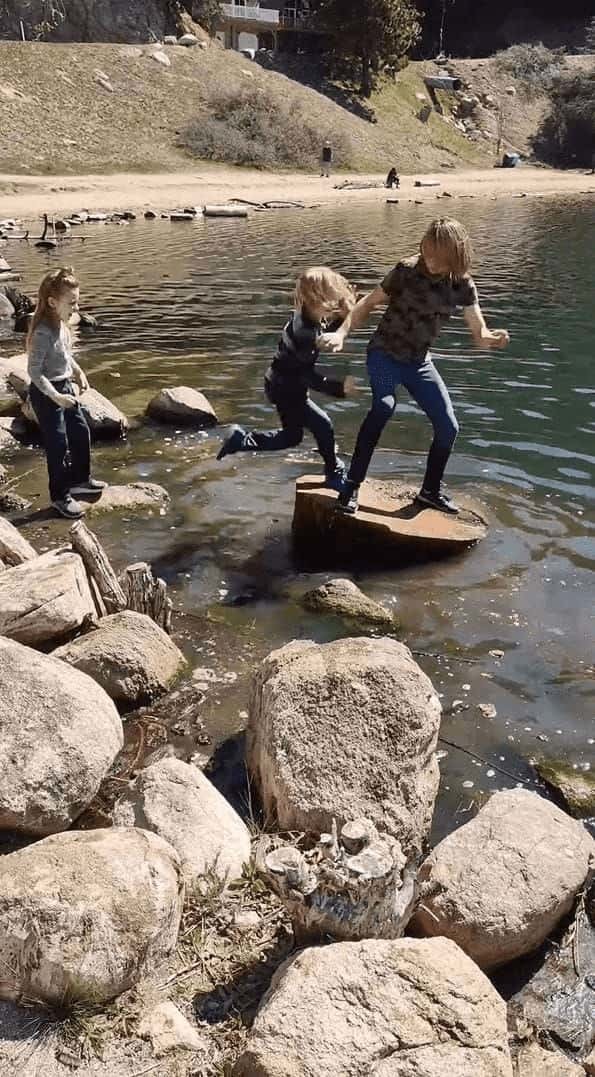 水辺に浮かぶ大きな丸太に乗る男の子。弟くんもそこに飛び乗ろうとしましたが、足を滑らせてしまい・・・