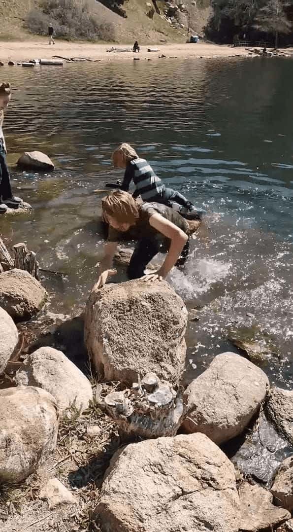 水辺に浮かぶ大きな丸太に乗る男の子。弟くんもそこに飛び乗ろうとしましたが、足を滑らせてしまい・・・