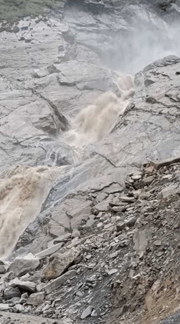 大雨の後、濁流となったネパールの山中にある滝。その脇をバスが走っていくのですが・・、スケール感がとんでもないことになっています！！