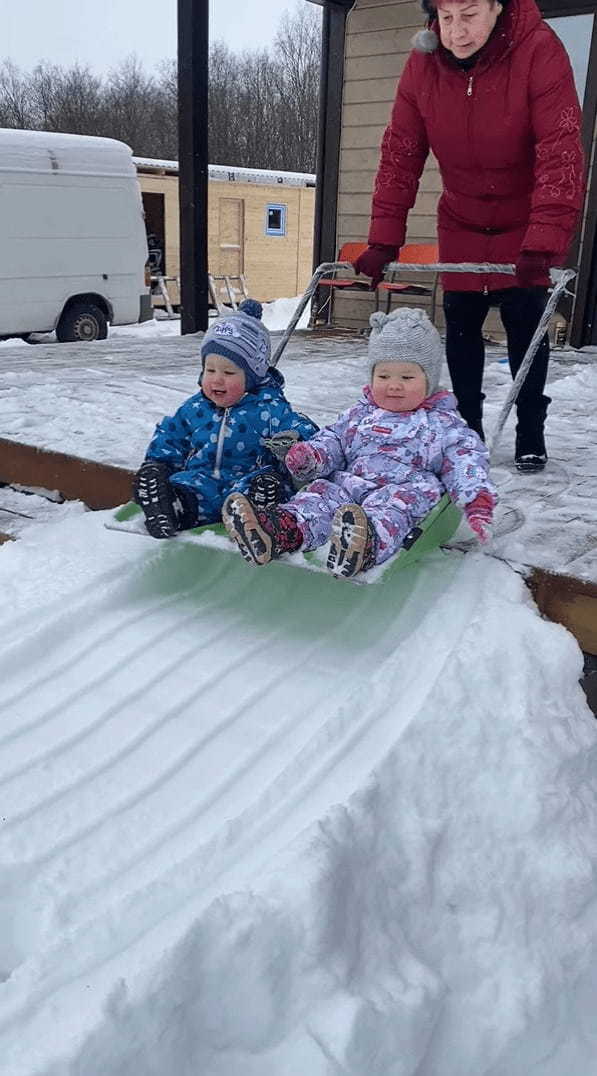 雪のすべり台で遊ぶ幼い子供たち。特大の雪かきスコップに乗せてもらって出発すると楽しくって笑いが止まりません！！【海外・動画】