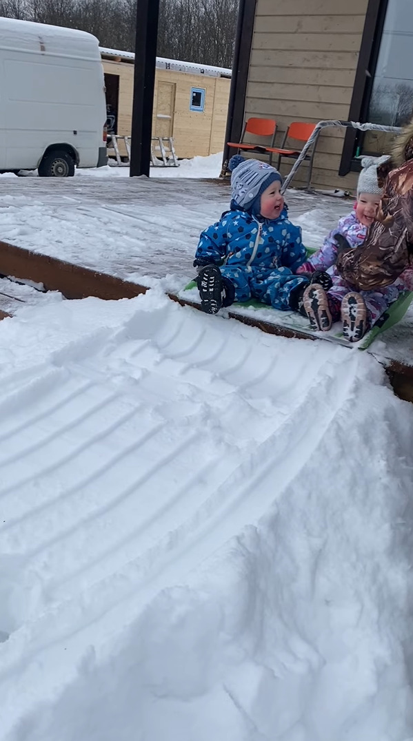 雪のすべり台で遊ぶ幼い子供たち。特大の雪かきスコップに乗せてもらって出発すると楽しくって笑いが止まりません！！【海外・動画】