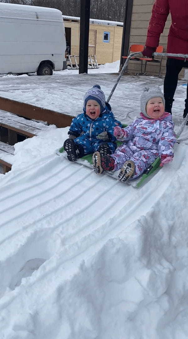 雪のすべり台で遊ぶ幼い子供たち。特大の雪かきスコップに乗せてもらって出発すると楽しくって笑いが止まりません！！【海外・動画】