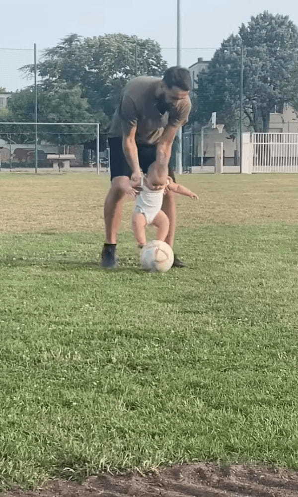 初めてサッカーをする赤ちゃん。パパに体を宙で支えられながらボールをちょんちょん！【海外・動画】