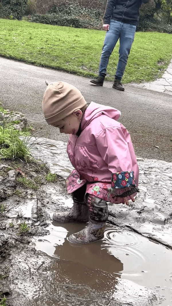 水たまりに入ってパシャパシャ！満面の笑みを浮かべ泥遊びを楽しむ幼い女の子、楽しみすぎてお顔にも泥が跳ねちゃっています！！