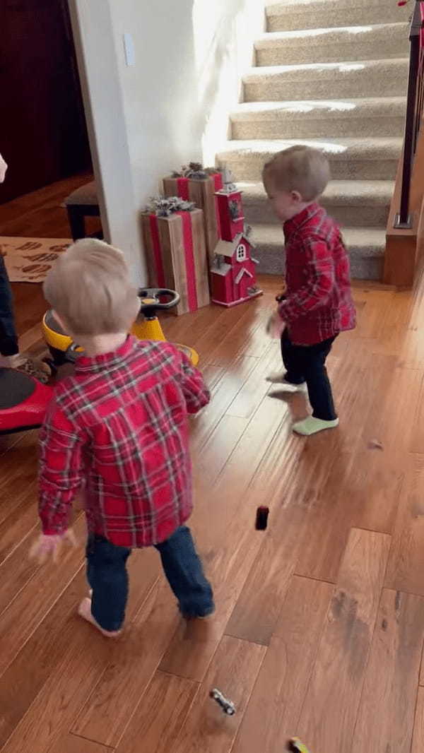 一足早いクリスマスプレゼントに大喜びする双子の男の子。手に持っていたオモチャの事をすっかり忘れてプレゼントに向かっていきます！