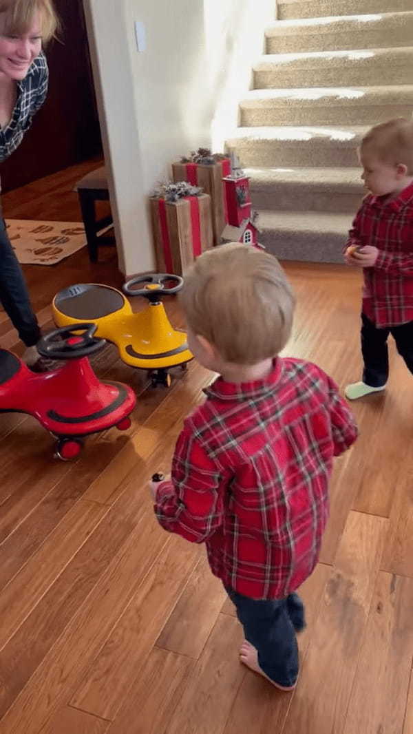 一足早いクリスマスプレゼントに大喜びする双子の男の子。手に持っていたオモチャの事をすっかり忘れてプレゼントに向かっていきます！