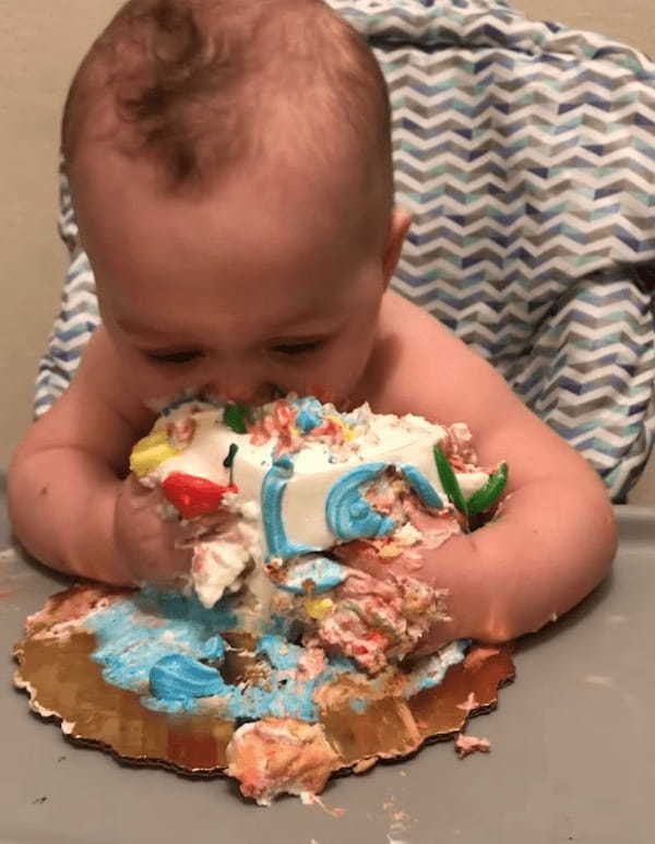 1歳のバースデーケーキとして「スマッシュケーキ」を食べる赤ちゃん。わしづかみにしたりかぶりついたりしたので、お顔がスゴいことに！！