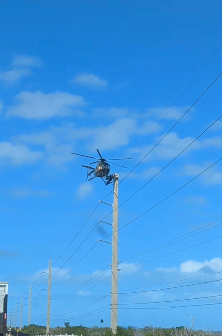 道路の上空でヘリコプターがホバリングしていると思ったら・・・、なんと機体を足場にして電線のメンテナンスをしている人がいたのです！！