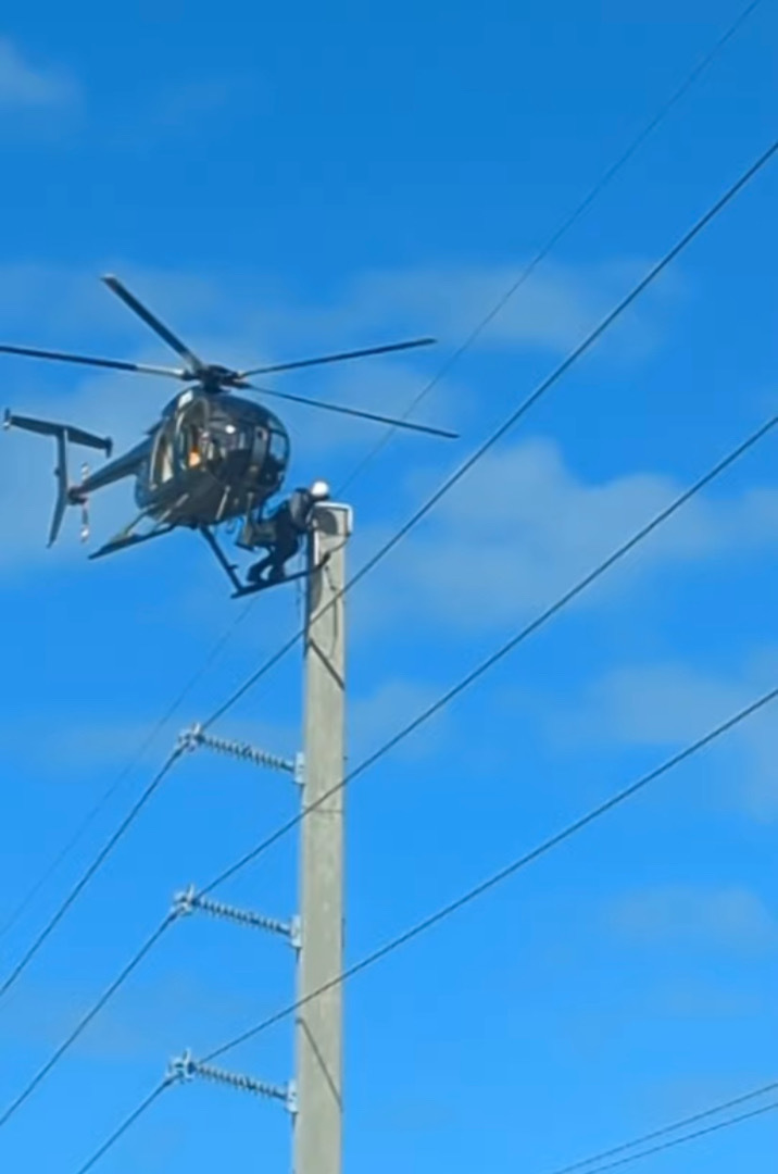 道路の上空でヘリコプターがホバリングしていると思ったら・・・、なんと機体を足場にして電線のメンテナンスをしている人がいたのです！！